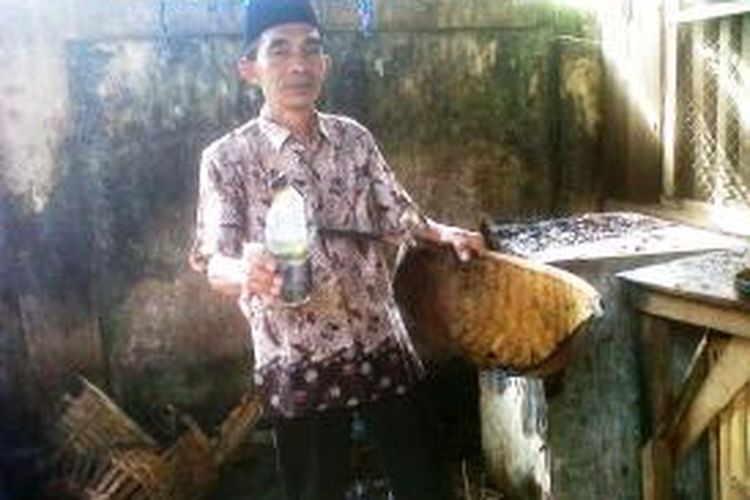 Salah satu pedagang pasar Kencong, Jember Jawa Timur, menunjukkan sisa bom molotov yang ditemukan di salah satu kios yang terbakar, Senin (6/1/14)