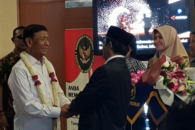 Mantan Menkopolhukam Wiranto dikalungi bunga oleh Menkopolhukam Mahfud MD sebelum meninggalkan Kantor Kemenkopolhukam, Rabu (23/10/2019).