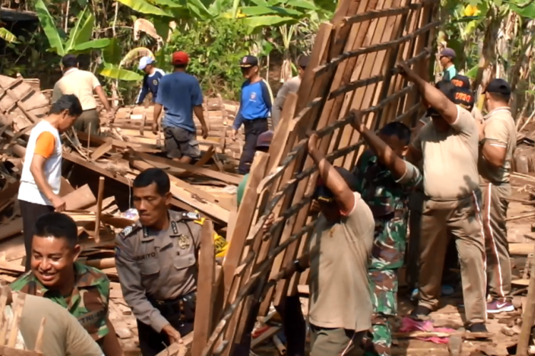 TNI dan Polisi serta relawan mengevakuasi rumah roboh.