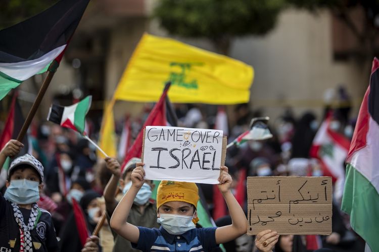 Warga Lebanon dan Palestina meneriakkan yel-yel serta mengibarkan bendera, dalam demo yang diadakan Hezbollah untuk menunjukkan solidaritas dengan orang-orang Palestina, di Beirut, Lebanon, pada Senin (17/5/2021).