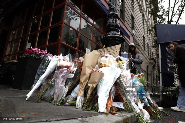 Para penggemar memberi penghormatan kepada mendiang aktor Matthew Perry dengan meletakkan bunga dan pesan di luar gedung Friends di New York City, Senin (30/10/2023). 