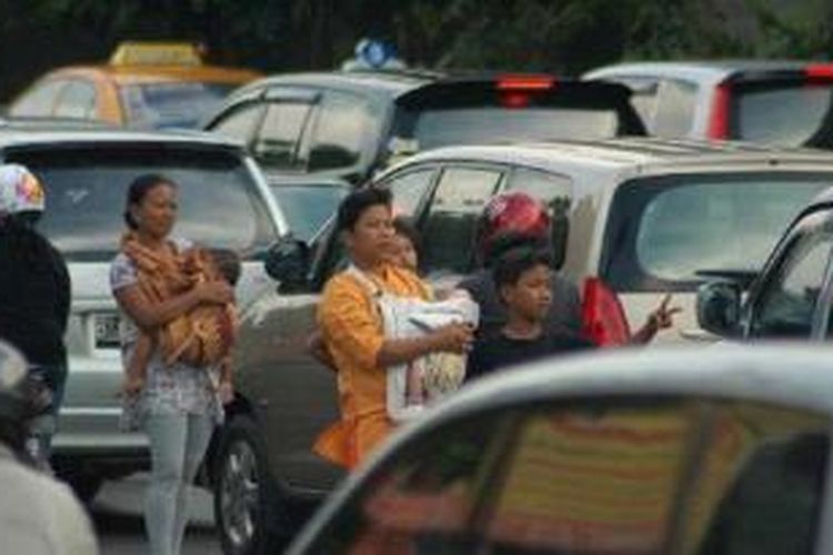 Seorang joki 3 in 1 menawarkan jasa kepada pengendara mobil yang lewat di ruas Jalan Gatot Subroto, Slipi, Jakarta, Selasa (28/9/2010). 