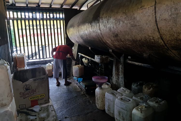 Pelayan di Toko Lim, Koja, Jakarta Utara sedang memproses pembelian minyak goreng dari pelanggan untuk dijual kembali, Senin (11/4/2022)..