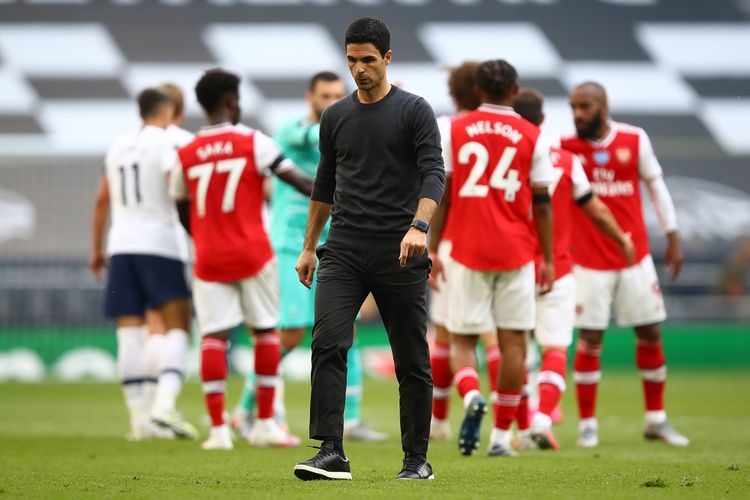 Mikel Arteta  berjalan usai kekalahan The Gunners pada laga Tottenham vs Arsenal di Tottenham Hotspur Stadium, London, Minggu (12/7/2020).