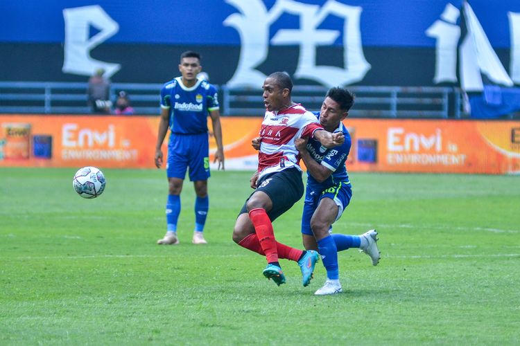 Penyerang Madura United Pedro Henrique Cortes, dihadang wing back Persib Daisuke Sato dalam duel Persib vs Madura United pada laga pekan kedua Liga 1 2022/2023, Sabtu (30/7/2022) di Stadion Gelora Bandung Lautan Api (GBLA).