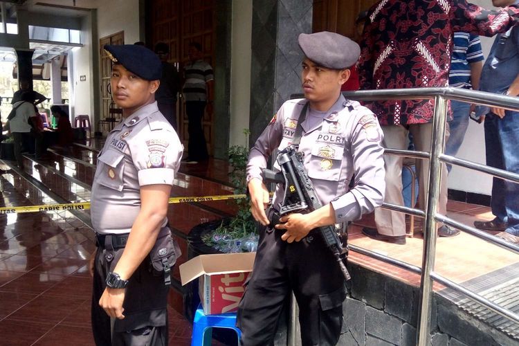 Polisi berjaga-jaga setelah terjadinya penyerangan di gereja Santa Lidwina Bedog Desa Trihanggo, Kecamatan Gamping, Minggu (11/2/2018). Akibat insiden ini, tiga umat dan satu orang romo yaitu Pastor Karl-Edmund Prier SJ, biasa dipanggil Romo Prier, serta satu orang petugas kepolisian yang berusaha menenangkan pelaku, mengalami luka sabetan pedang dan harus dilarikan ke rumah sakit.