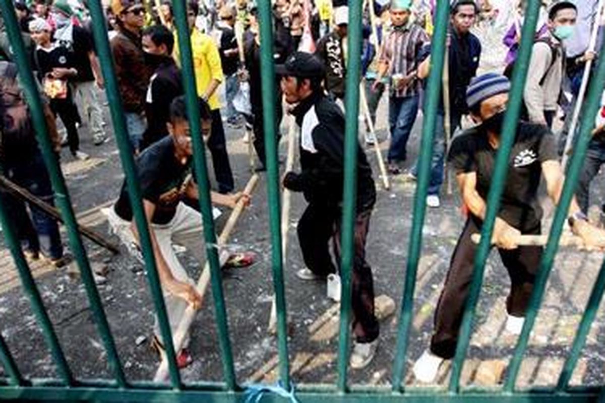 Pengunjuk rasa memukul pagar dan melempari polisi dengan batu saat terjadi bentrokan di depan gedung DPR RI, Jakarta, Selasa (2/3/2010).