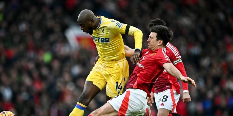 Duel antara Jean-Philippe Mateta dan Harry Maguire dalam laga pekan ke-24 Liga Inggris 2024-2025 antara Man United vs Crystal Palace di Stadion Old Trafford, 2 Februari 2025. (Photo by Paul ELLIS / AFP) 