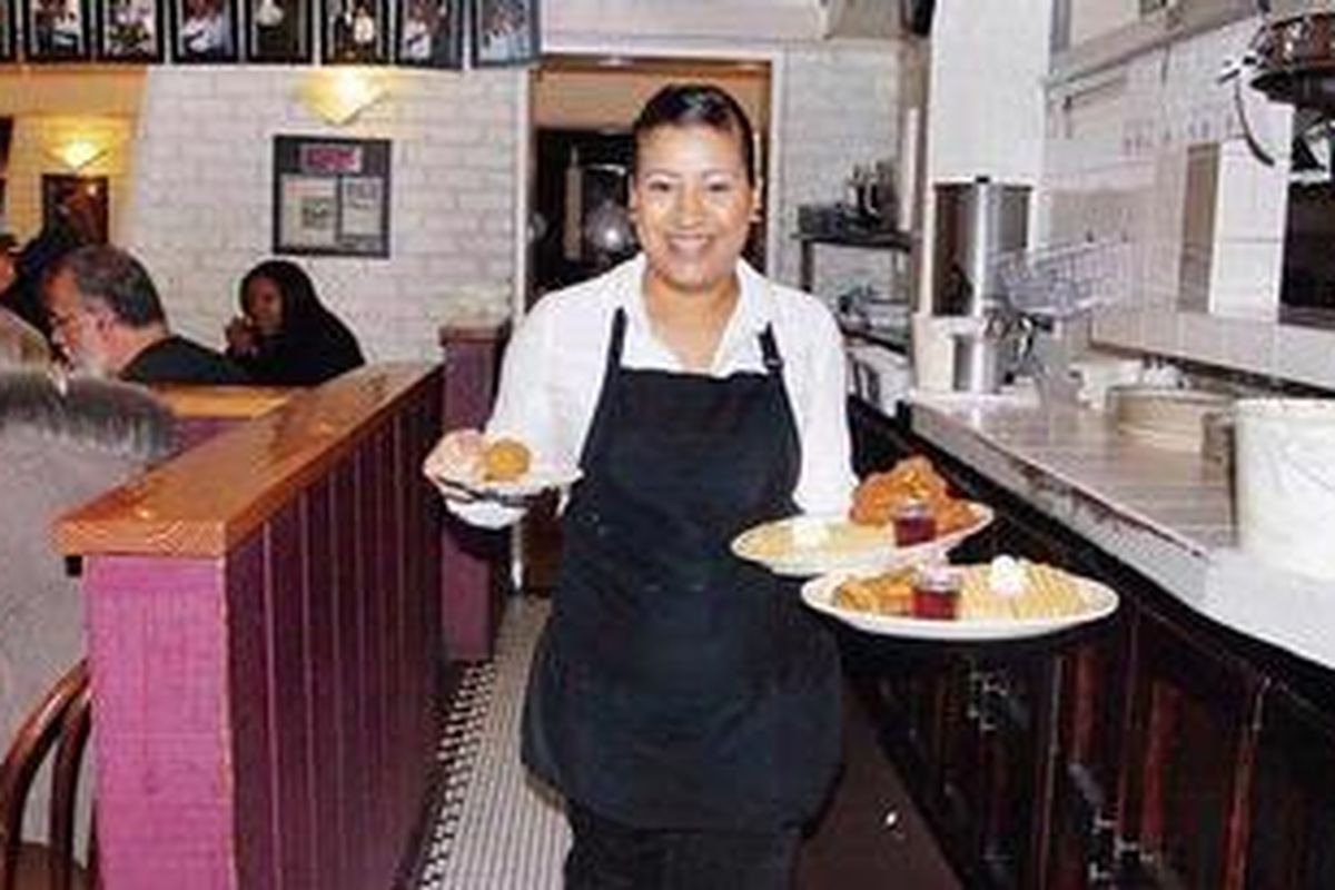 Kenia , salah seorang karyawan di Roscoes menghidangkan menu andalan: wafel dan ayam goreng.