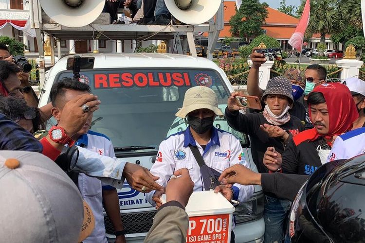 Protes kenaikan UMP Jatim, buruh aksi patungan uang koin Rp 700 di depan gedung negara Grahadi Surabaya Senin (22/11/2021).
