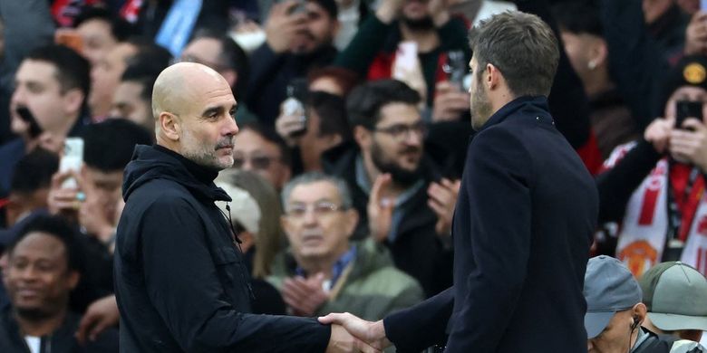 Pelatih Manchester City, Pep Guardiola, bersalaman dengan bos Man United, Michael Carrick. Manchester City harus menerima kekalahan 0-2 dari rival sekota Manchester United dalam derbi Manchester yang digelar Sabtu (17/1/2026).