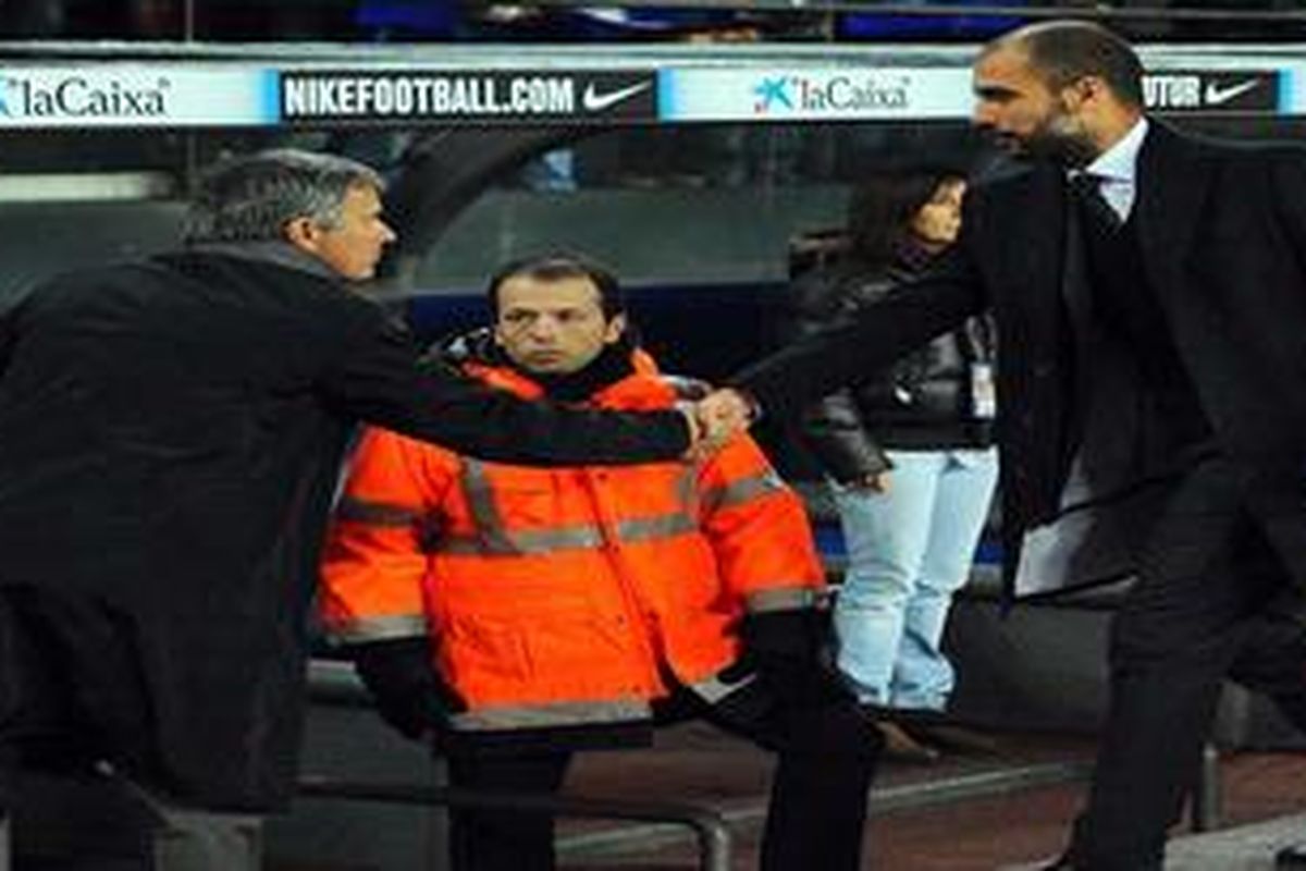 Manajer Real Madrid, Jose Mourinho (kiri), memberikan selamat kepada pelatih Barcelona, Josep Guardiola, usai anak-anak didik mereka bertanding di panggung Liga BBVA, Selasa (30/11/2010), yang berakhir 5-0 untuk Barcelona.