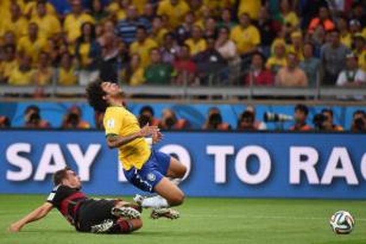 Pemain Jerman Philipp Lahm (bawah) terjatuh bersama pemain Brasil Marcelo dalam laga semifinal Piala Dunia 2014 di Mineirao Stadium, Belo Horizonte, Brasil, 8 Juli 2014. Brasil harus mengakui keunggulan Jerman dengan skor akhir 7-1.