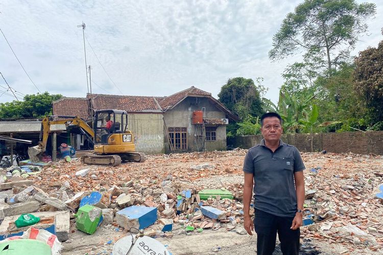 Jaenudin, Kepala Desa Sajira Mekar, Kecamatan Sajira, Kabupaten Lebak, Banten berdiri di depan puing-puing rumahnya yang terbakar Rabu (3/11/2022)