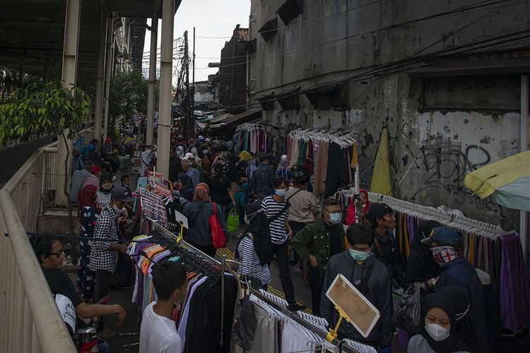 Sejumlah warga berbelanja di pedagang kaki lima (PKL) tepi trotoar sekitar Pusat Grosir Pasar Tanah Abang, Jakarta Pusat, Minggu (2/5/2021). Gubernur DKI Anies Baswedan mengakui adanya lonjakan pengunjung di pusat tekstil terbesar se-Asia Tenggara tersebut, dari sekitar 35.000 pengunjung pada hari biasa menjadi sekitar 87.000 orang pada akhir pekan ini sehingga pihaknya menyiagakan sekitar 750 petugas untuk menjaga kedisiplinan protokol kesehatan untuk mencegah penularan COVID-19.