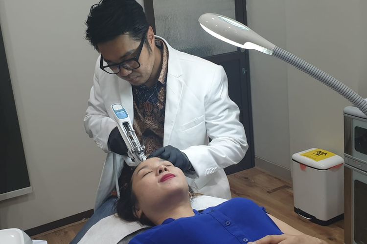 Dokter Frans Herry Widjaja mempratikkan cara memasukkan serum ke kulit kepala untuk mengatasi kebotakan.