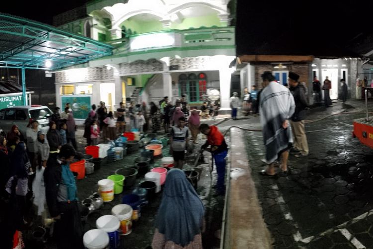 Warga antre air bersih dari BPBD Kabupaten Wonosobo di depan halaman masjid setempat pada Minggu (10/12/2023) malam 