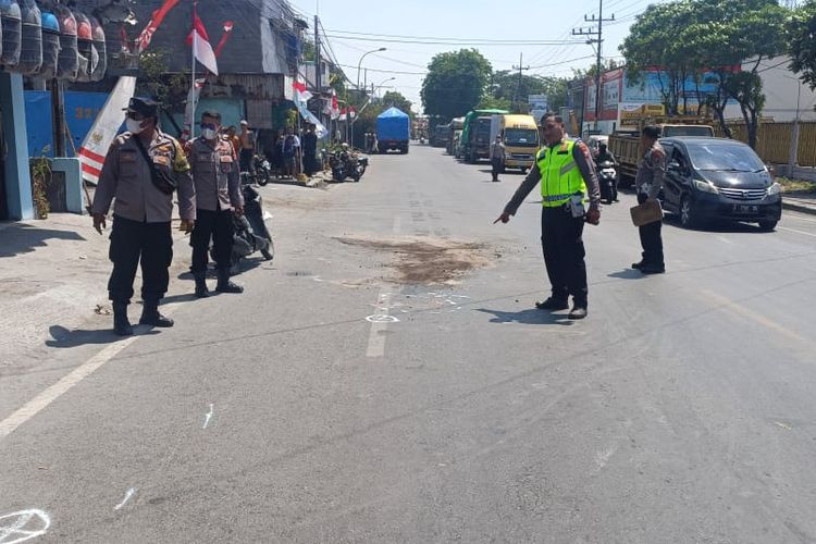 Pihak kepolisian saat olah di lokasi kejadian kecelakaan lalu lintas yang terjadi di Jalan Raya Desa Roomo, Kecamatan Manyar, Gresik, Jawa Timur, Senin (14/8/2023).