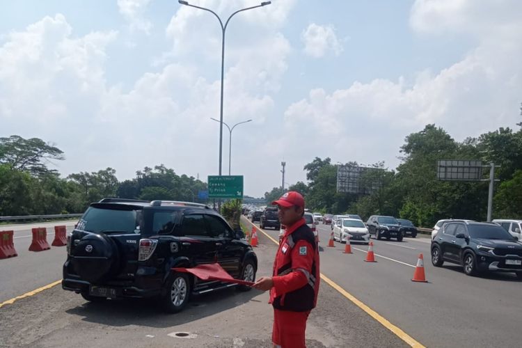 Petugas Tol Jagorawi sedang mengarahkan kendaraan setelah diberlakukan Contraflow di ruas tol arah Jakarta dari Km 17+200 sampai Km 11+700 Tol Jagorawi, Sabtu (22/4/2023)