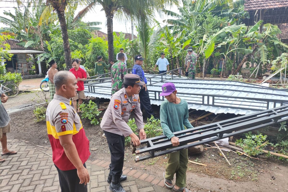 Petugas bahu membahu membersihkan rumah yang rusak diterjang angin puting beliung pada Rabu (3/7/2024) di Banyuwangi. 