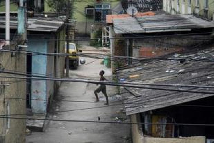 Foto yang direkam anak-anak dalam proyek fotografi yng dikelola AFP untuk anak kawasan kumuh Cidade de Deus. Seorang bocah bermain sepak bola di jalanan Cidade de Deus (Kota Tuhan), Rio de Janeiro, Brasil, 13 April 2014.