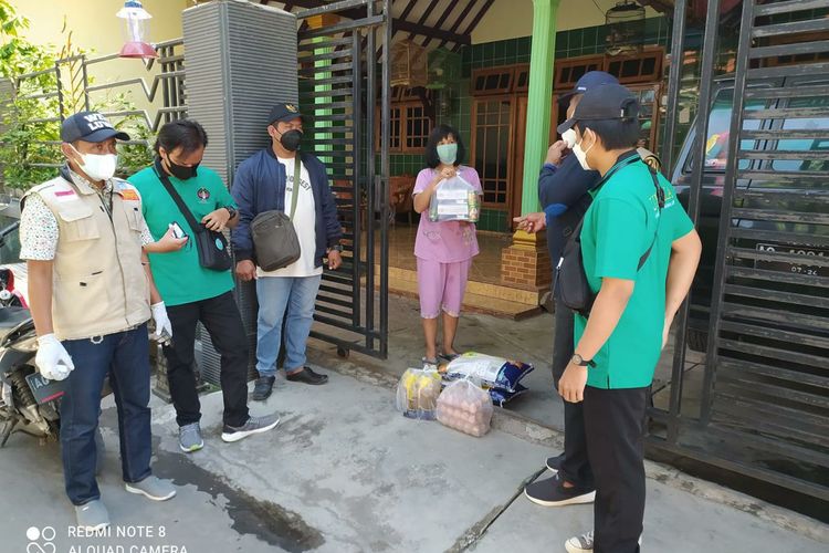 Petugas PPKM Mikro Kelurahan Burengan tengah Ronda Isoman untuk pengecekan kesehatan sekaligus memberikan bantuan sembako.