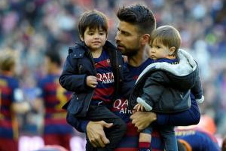 Pemain bertahan Barcelona, Gerrard Pique, menggendong dua anaknya, Milan (kiri) dan Sasha, sebelum menjalani laga melawan Real Sociedad di Camp Nou, Barcelona, Senin (28/11/20105).