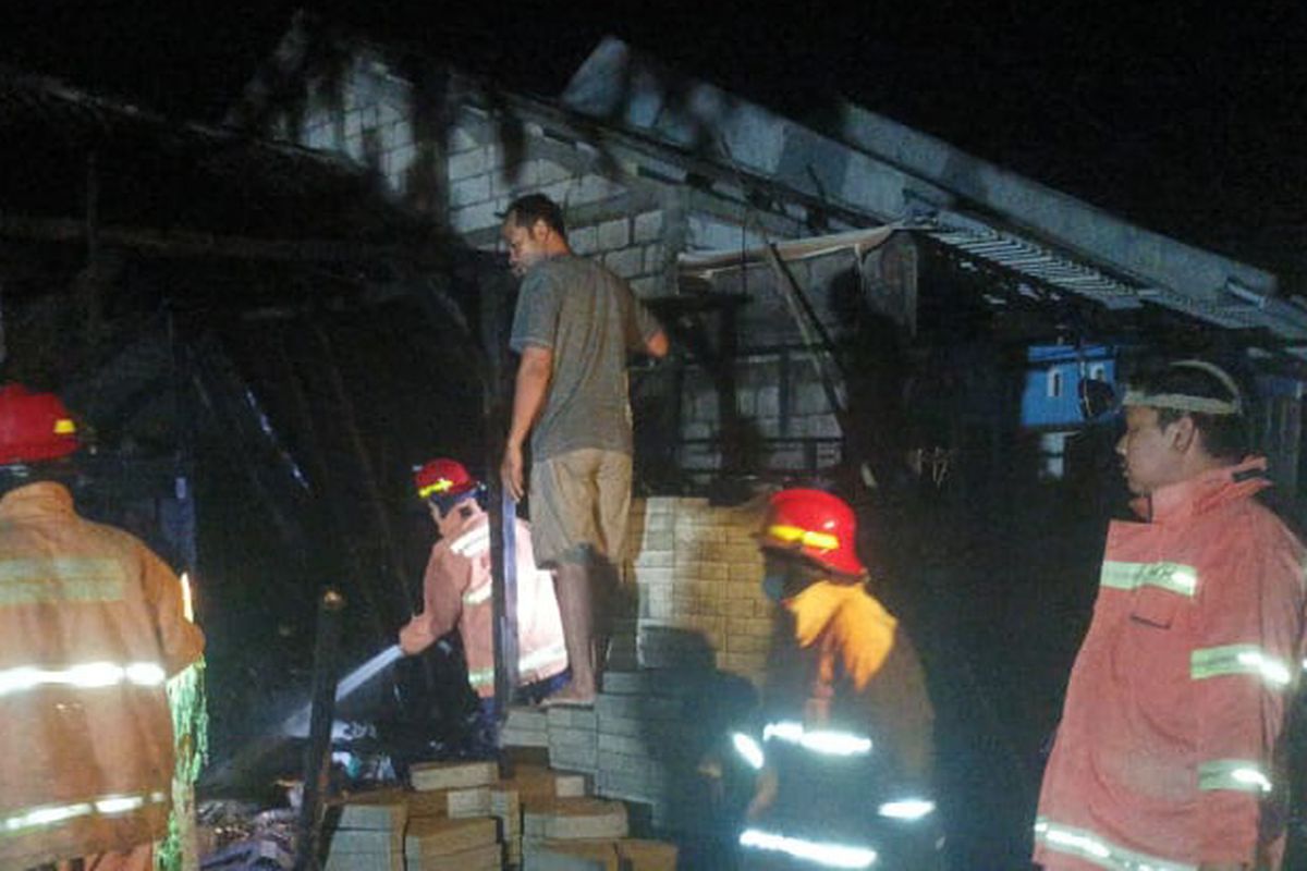 Petugas dari Dinas Damkarla Gresik saat melakukan proses pemadaman api yang membakar rumah Noto di Desa Dapet, Kecamatan Balongpanggang, Gresik, Jawa Timur, Rabu (14/9/2022).