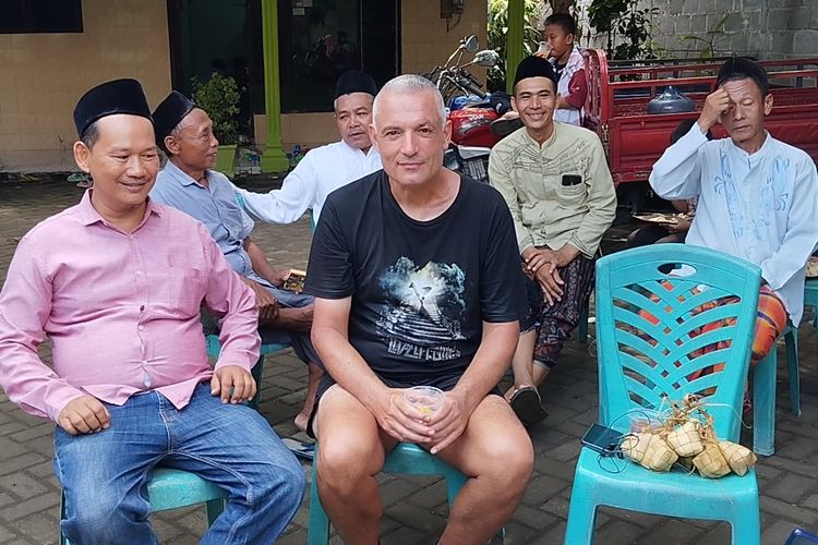 Reiner, seorang pria asal Jerman, saat mencicipi ketupat lebaran di Festival Ketupat Masjid Al Ahmad Kelurahan Pojok, Kecamatan Mojoroto, Kota Kediri, Jawa Timur,  Minggu (14/4/2024).