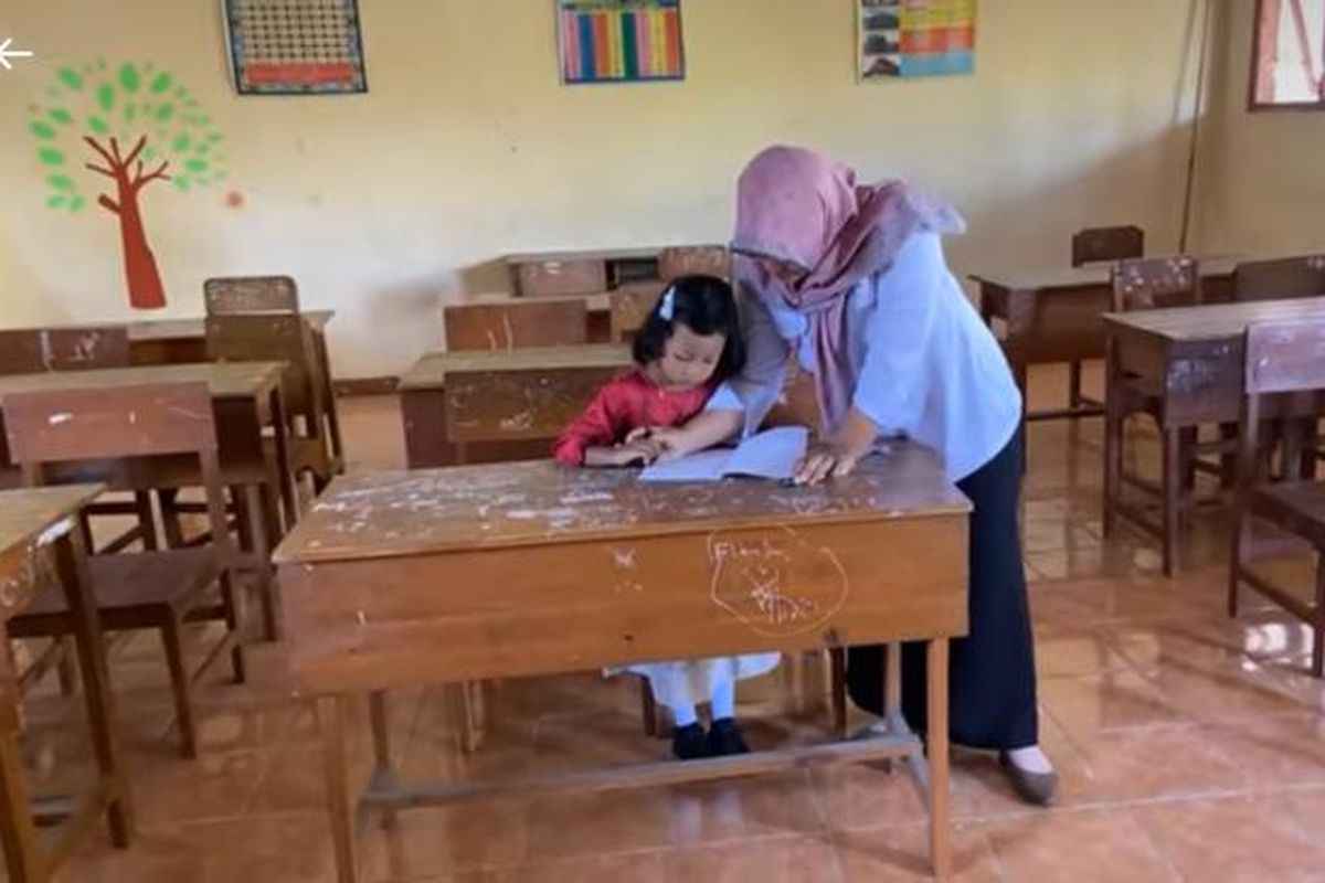 Meski sendirian masuk kelas 1 SDN 1 Setono, Kecamatan Jenengan, Kabupaten Ponorogo, Jawa Timur tak membuat Ira (7) ciut nyali. Mengenakan baju terusan warna atas merah bawah biru muda, diantar kakeknya, Ira percaya diri masuk ke dalam kelas,Senin (17/7/2023) pagi.   