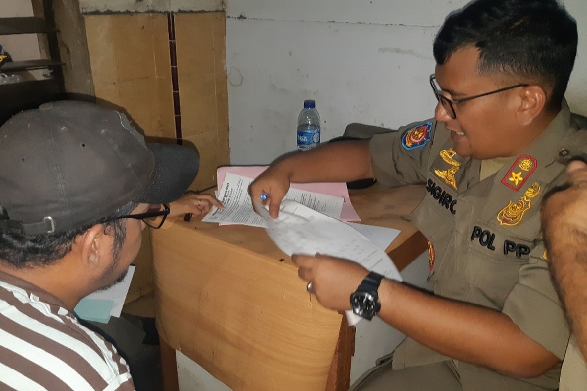 Kasatpol PP Tambora Ivand Sigiro  menjelaskan soal perizinan indekos kepada anak seorang pemiliki indekos di kawasan Krendang, Jakarta Barat, Kamis (24/10/2019). 