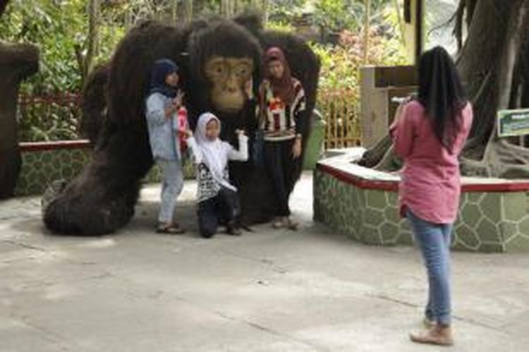 Pengunjung berfoto di depan patung orangutan di Kebun Binatang Gembira Loka, Daerah Istimewa Yogyakarta, Jumat (29/8/2014). Kebun binatang yang memiliki luas sekitar 20 hektar ini menjadi salah satu tempat wisata yang diminati warga.