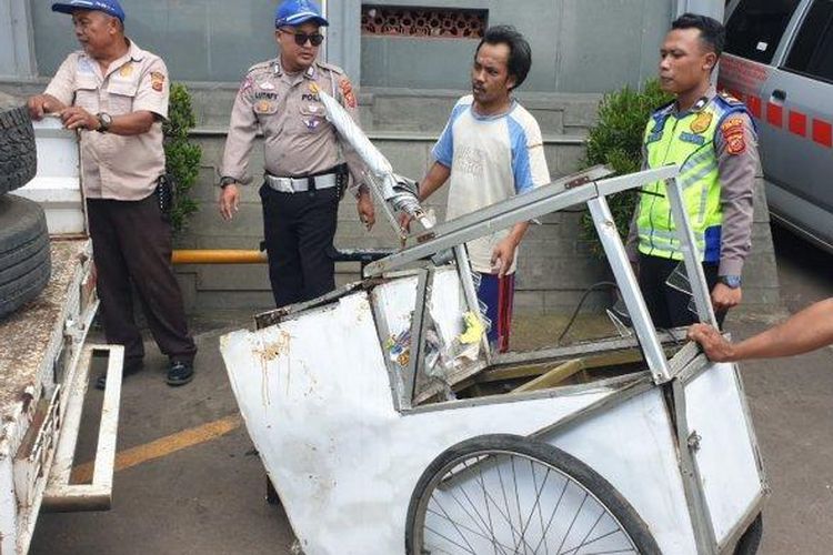 Polisi saat melakukan olah TKP di lokasi pedagang rujak dihantam ban truk kontainer, Senin (26/2/2024).

