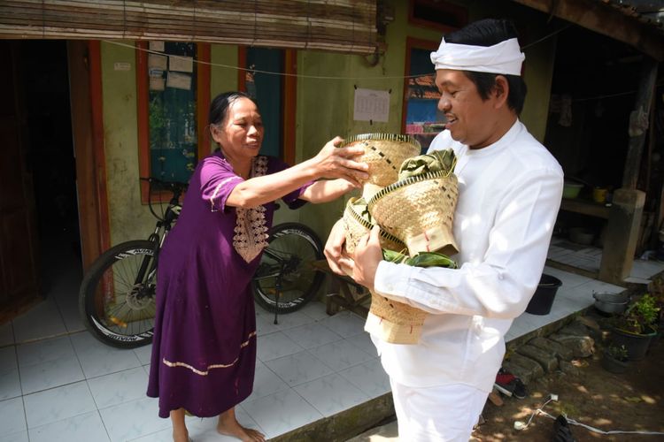 Wakil Ketua Komisi IV DPR RI Dedi Mulyadi membagikan daging sapi yang dibungkus daun jati kepada warga di Purwakarta, Jawa Barat, Kamis (30/7/2020). 