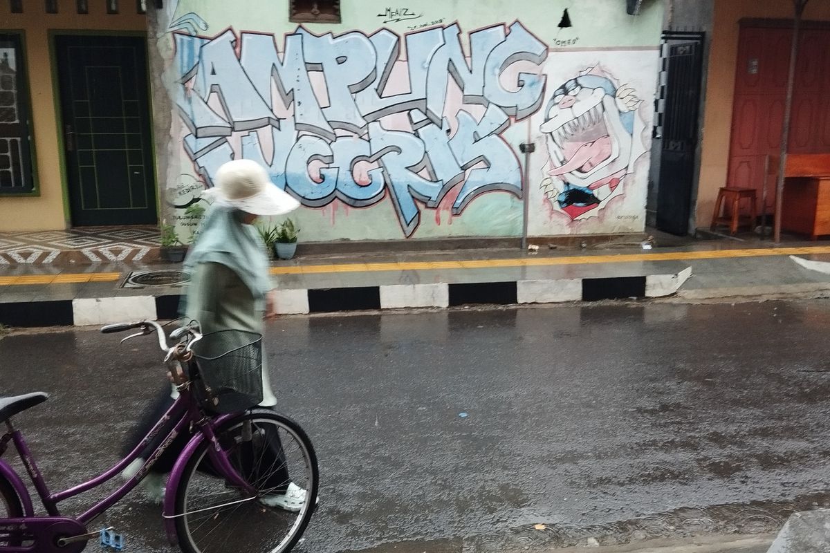 Seorang pelajar melintas di depan mural bertuliskan Kampung Inggris di kawasan Kampung Inggris, Kecamatan Pare, Kabupaten Kediri, Jawa Timur.