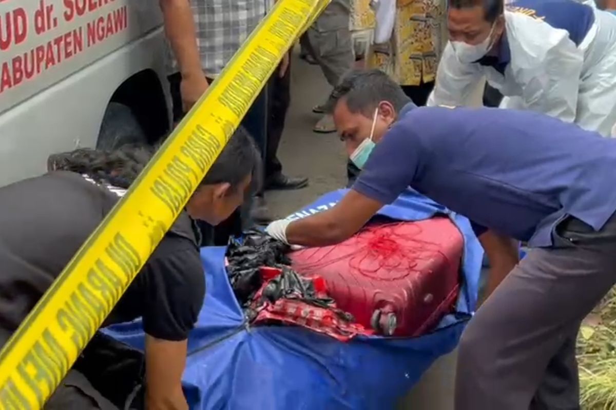 EVAKUASI—Tim Inafis Polres Ngawi mengevakuasi koper merah berisi jasad perempuan telanjang di Desa Dadapan, Kecamatan Kendal, Kabupaten Ngawi, Jawa Timur, Kamis (23/1/2025).