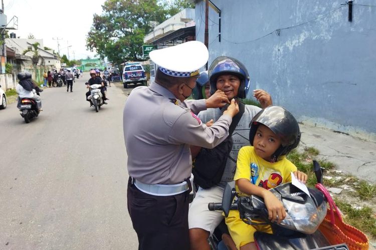 Seorang petugas Direktorat Lalu Lintas Polda Gorontalo memberikan pemahaman keselamatan berlalu lintas kepada seorang pengendara motor yang terjaring Operasi Zebra Otanaha 2022.