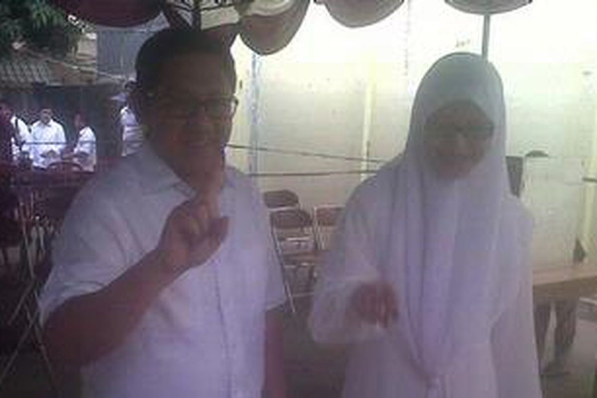 Anas Urbaningrum bersama istrinya Atthiyah Laila seusai memberikan suara pada Pilkada DKI putaran kedua di TPS 090, Duren Sawit, Jakarta Timur, Kamis (20/9/2012).