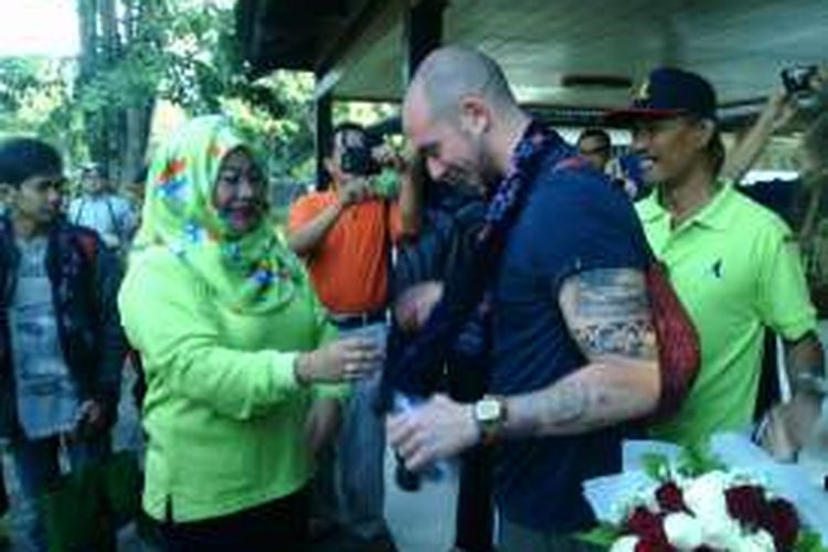 Kepala Unit PT TWC Chrisna Murti Adiningrum mengalungkan bunga kepada wisman pertama yang masuk ke Candi Borobudur, Minggu (1/1/2017).