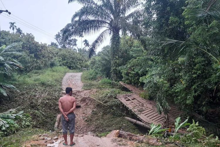 Warga melihat jembatan yang rusak akibat banjir yang menghubungkan Desa Bukit Linteung dan Desa Seureuke, Kecamatan Langkahan, Kabupaten Aceh Utara, Provinsi Aceh, Jumat (26/8/2022)