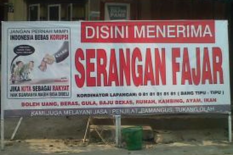 Spanduk berisikan menerima serangan fajar dari caleg, dipajang di pinggir jalan raya di Jalan Nagur, Pematangsiantar, Sumatera Utara, Kamis (13/3/2014).