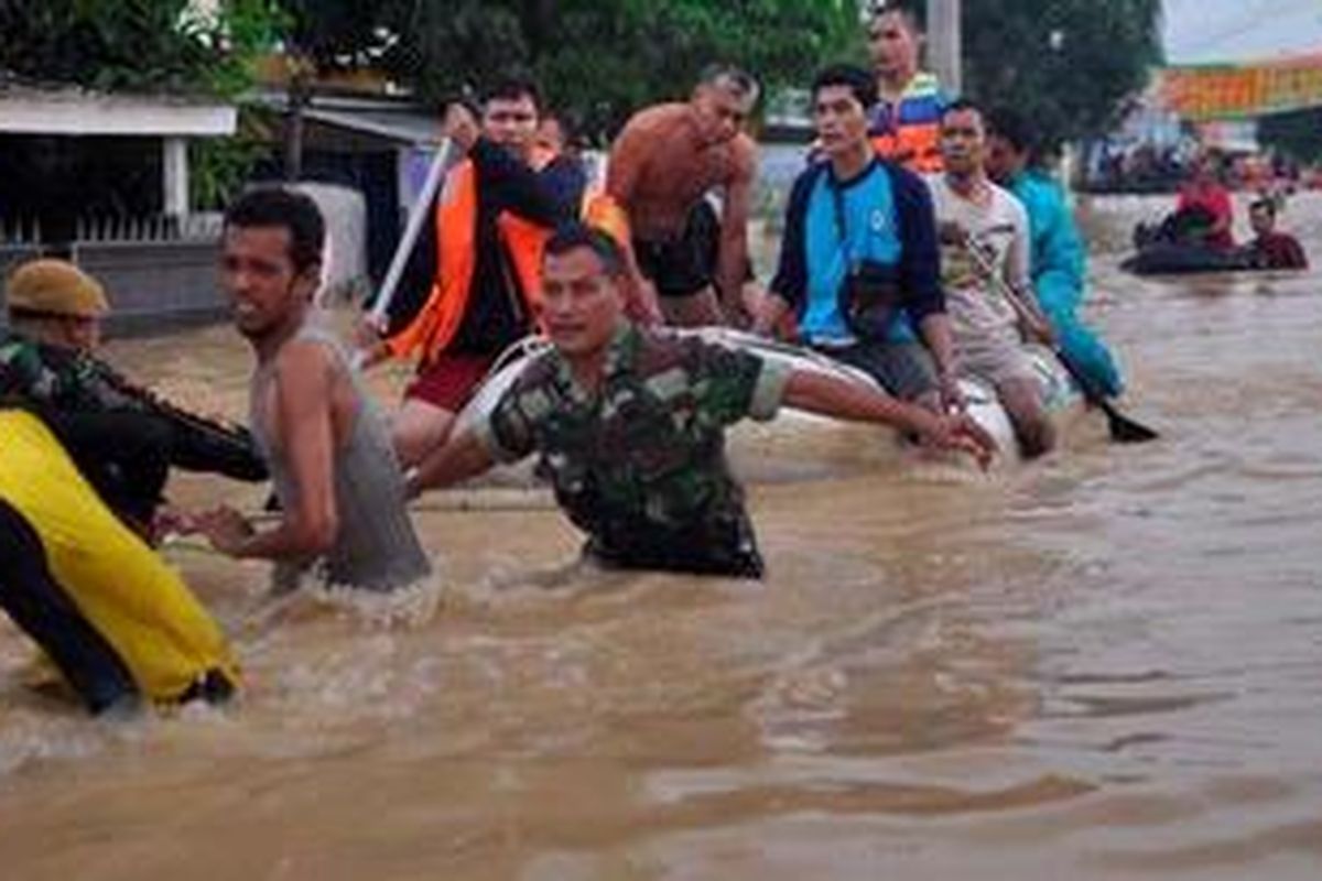Tim SAR mengevakuasi warga yang kebanjiran akibat tanggung Sungai Bekasi jebol dan merendam Perumahan Pondok Gede Permai, Jatiasih, Kota Bekasi, Jumat (18/1/2013). Banjir di Kota Bekasi memaksa sekitar 11.000 jiwa mengungsi.