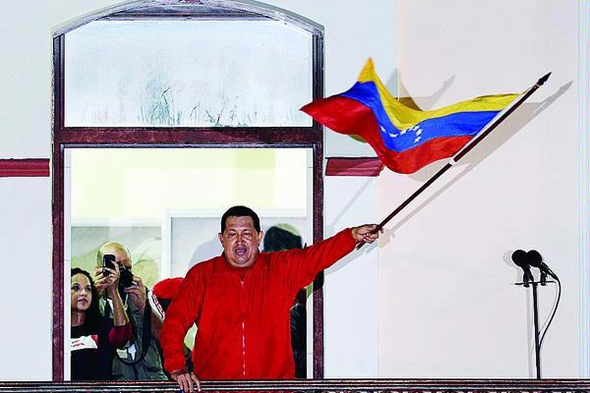 Hugo Chavez melambaikan bendera Venezuela ketika berbicara di depan pendukungnya seusai memenangi pemilihan umum presiden. Chavez memperoleh 55 persen suara, mengalahkan pesaingnya,   Henrique Capriles, yang mendapat 45 persen suara.