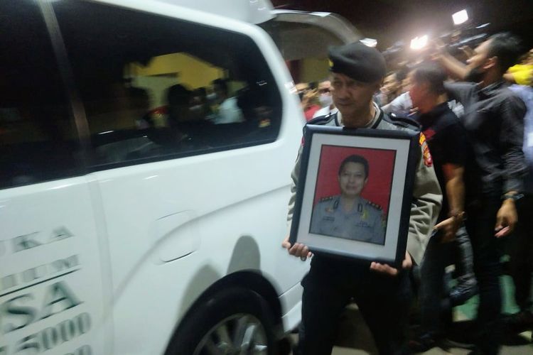 Seorang anggota polisi memegang bingkai foto Kasat Narkoba Polres Metro Jakarta Timur AKBP Buddy Alfrits Towoliu di RS Polri Kramat Jati, Jakarta Timur, Sabtu (29/4/2023)