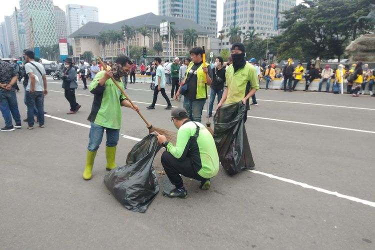 Petugas PPSU bersih-bersih sampah imbas adanya aksi unjuk rasa di kawasan Patung Kuda, Kamis (21/4/2022).