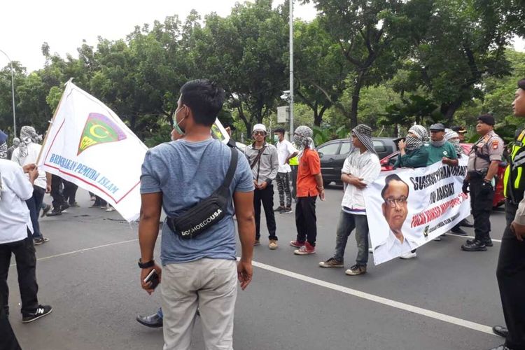 Massa Gerakan Pemuda Islam yang tolak DWP bentangkan spanduk hingga tutupi jalan di depan Balai Kota, Jalan Medan Merdeka Selatan, Kamis (12/12/2019)