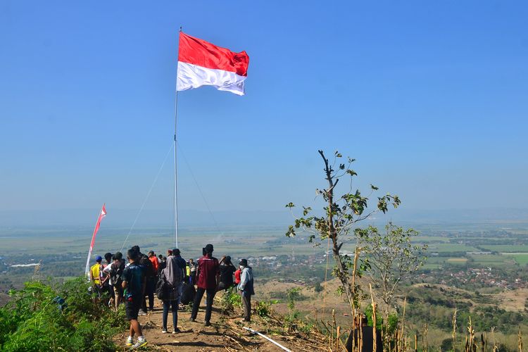 Sejumlah warga mengikuti pengibaran bendera Merah Putih di bukit Cangkraman, Pegunungan Patiayam, Desa Terban, Kudus, Jawa Tengah, Rabu (11/8/2021). Pengibaran bendera Merah Putih berukuran 3 x 5,5 meter di atas bukit setinggi kurang lebih 350 meter di atas permukaan laut dengan menyanyikan lagu Indonesia Raya itu untuk menyambut HUT ke-76 Kemerdekaan RI serta meningkatkan rasa nasionalisme. ANTARA FOTO/Yusuf Nugroho/wsj.