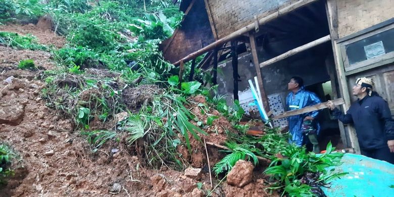 Dua petugas  mengecek lokasi bencana tanah longsor di Kampung Cikiray, Desa Sirnaresmi, Cisolok, Sukabumi, Jawa Barat, Minggu (16/2/2020).