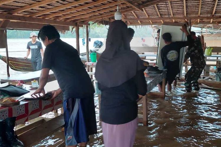 Petugas TNI membantu warga menyelamatkan peralatan rumah tangga dari banjir bandang yang melanda, di Kecamatan Kampar Kiri Hulu, Kabupaten Kampar, Riau, Sabtu (11/3/2023).