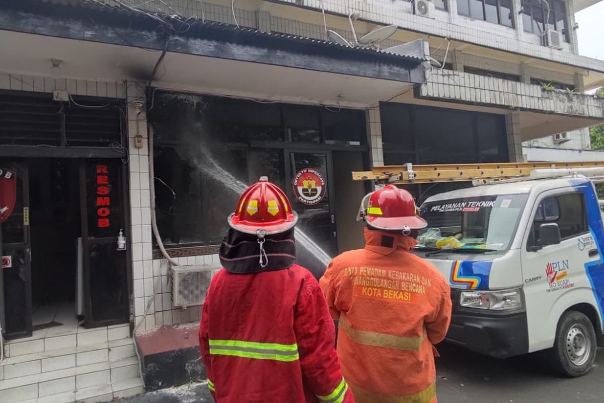 Dinas Damkar Kota Bekasi saat memadamkan api di ruang Humas Polsek Bekasi Kota pada Senin (1/5/2023). Penyebab kebakaran diduga dari korsleting panel listrik.
